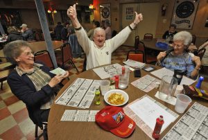 Bingo, Rosedale, MD -- 2011 -- Bill James, 80, of Rosedale, center, celebrates after winning $95 in a "full card" game, as his wife Mary James, 76, left, and friend Thelma Sutphin, 68, of Middle River, look on, at VFW Post 6506. The VFW Post wanted to hold casino nights with card games and roulette to raise more money, if the legislature approved an expansion of gambling. (Amy Davis / Baltimore Sun)